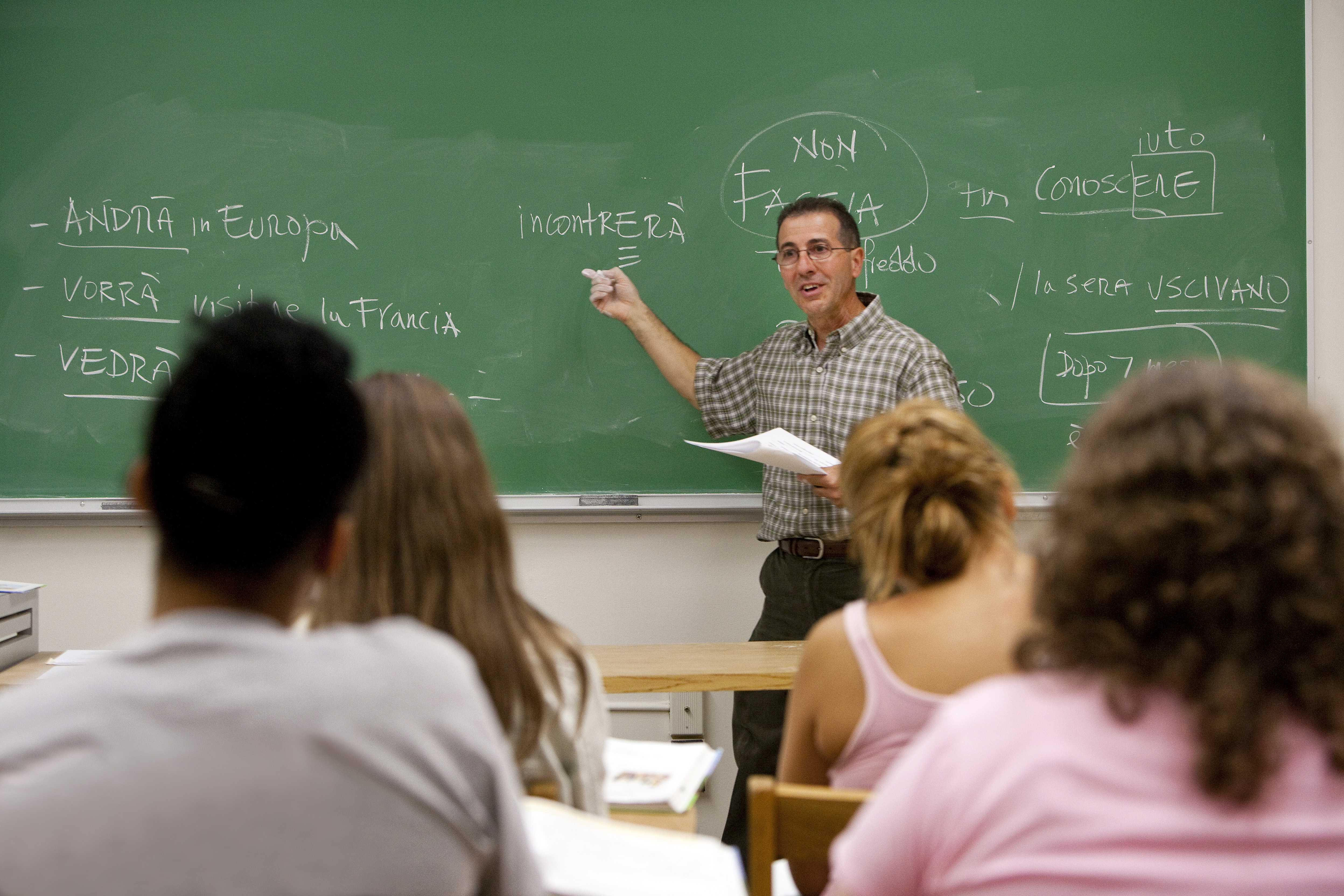 Professor teaching in front of a class using the chalkboard