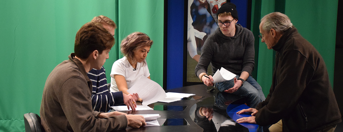 Journalism students and professor preparing for a news broadcast
